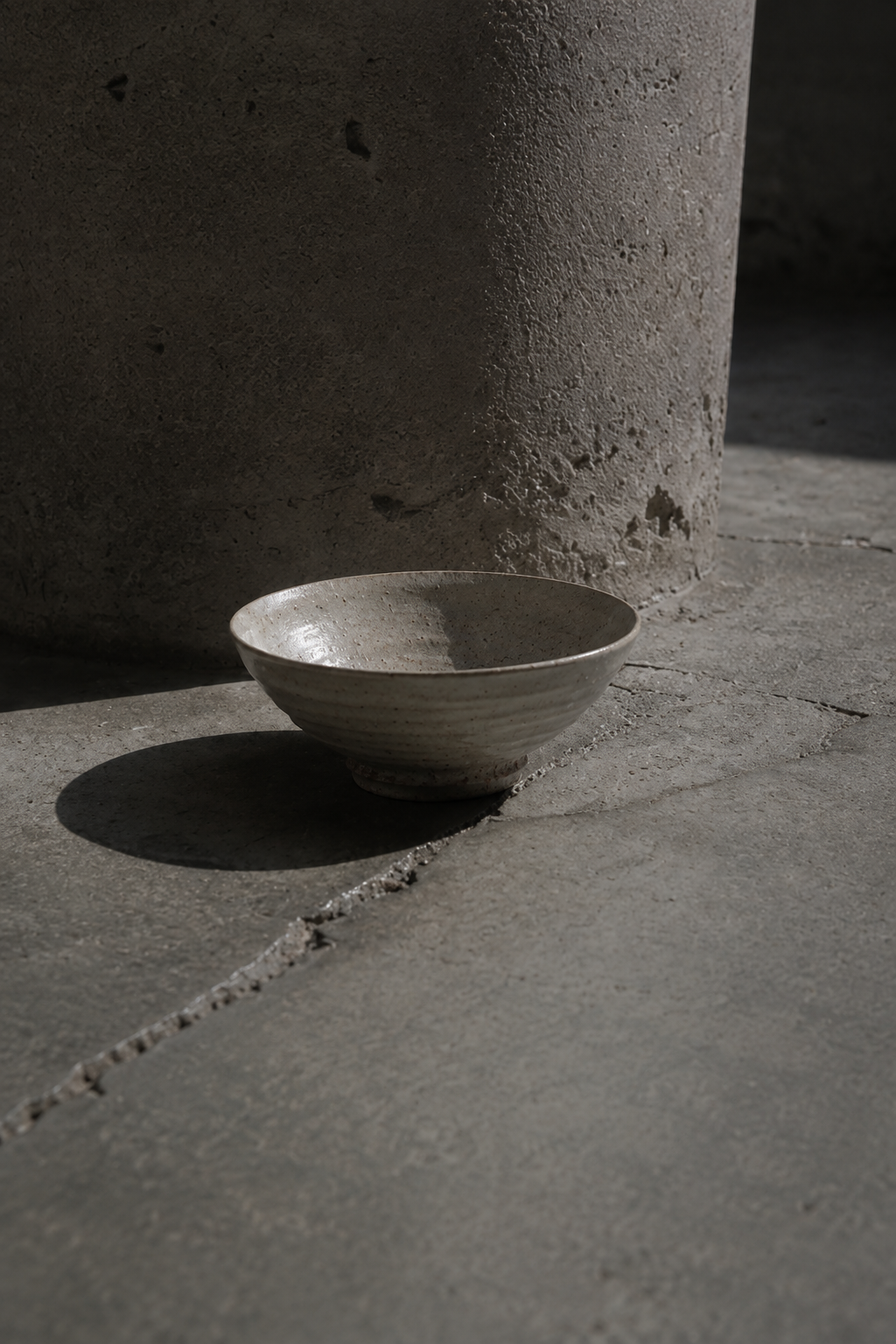 Karehagi Chawan on concrete pillar, hard light — desire hero